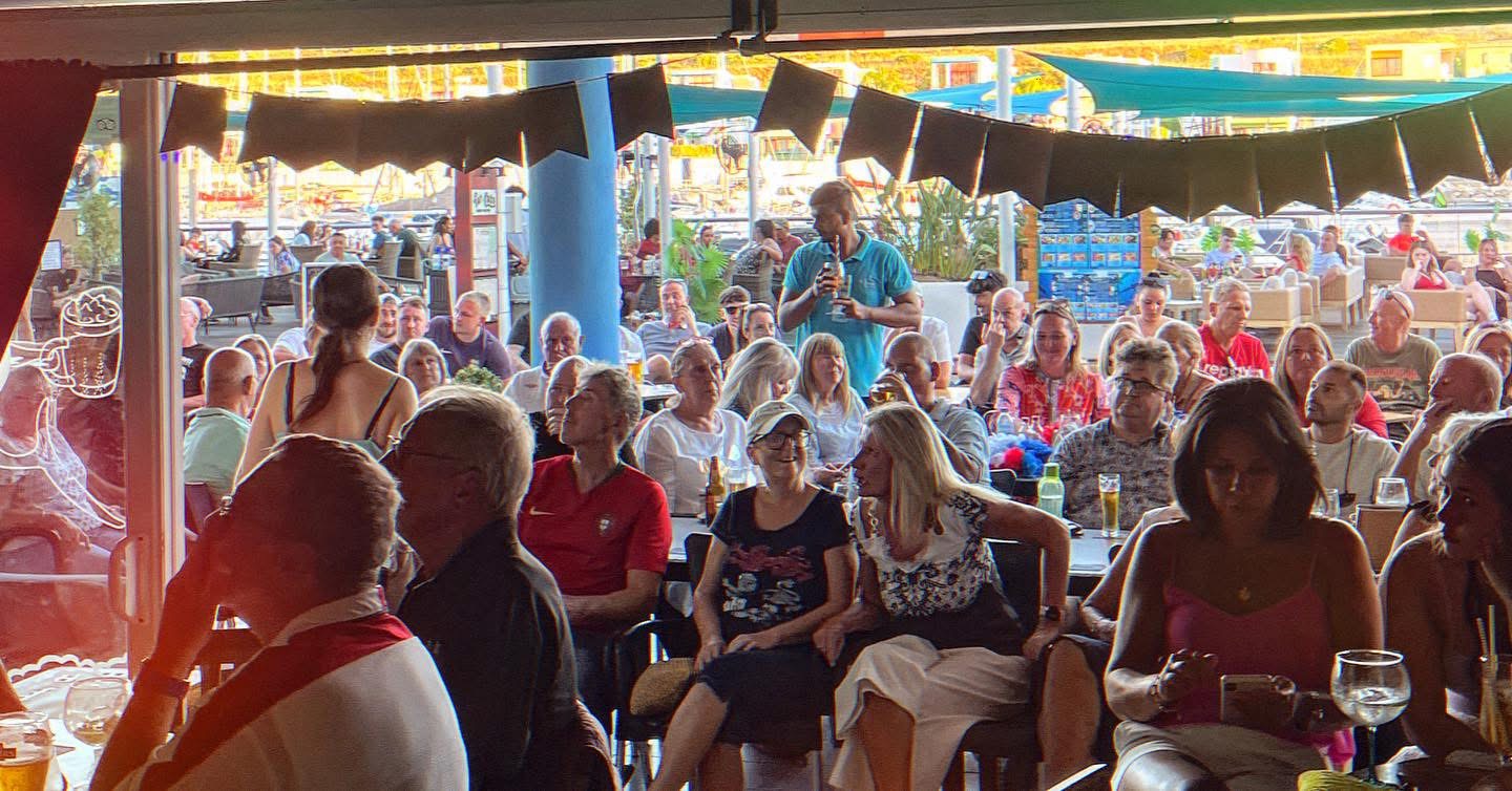 Crowd watching live sports at Sharky's Bar